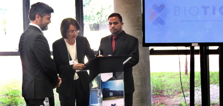 Foto com Glória Guimarães assinando documento da parceria nom Biotic