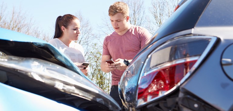 Imagem de pessoas utilizando celular logo após um acidente de trânsito