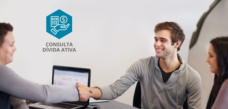 Foto com um casal, de um lado da mesa, e um homem, do outro lado. Na mesa, um computador. Os dois homens sorriem e apertam as mãos. A imagem também traz a logomarca do produto Consulta Dívida Ativa. Foto com um casal, de um lado da mesa, e um homem, do outro lado. Na mesa, um computador. Os dois homens sorriem e apertam as mãos. A imagem também traz a logomarca do produto Consulta Dívida Ativa.