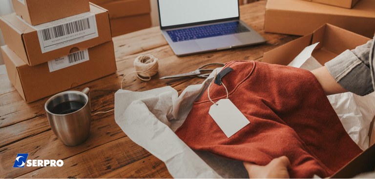 Funcionário de loja que vende pela internet embala uma blusa para entrega pelos Correios Funcionário de loja que vende pela internet embala uma blusa para entrega pelos Correios