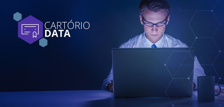 Homem trabalhando em um computador. À esquerda, marca do Cartório Data Homem trabalhando em um computador. À esquerda, marca do Cartório Data
