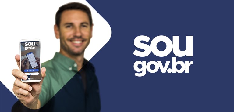 Ilustração com foto. Num fundo branco, foto de homem que exibe um smartphone com a mão direita. Na tela, a marca Sou Gov e a imagem de outro celular. À direita, num fundo azul, o texto na cor branca: Sou Gov.Br. Ilustração com foto. Num fundo branco, foto de homem que exibe um smartphone com a mão direita. Na tela, a marca Sou Gov e a imagem de outro celular. À direita, num fundo azul, o texto na cor branca: Sou Gov.Br.