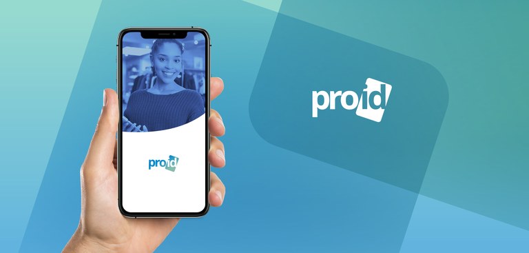 Mão segurando um telefone celular cuja tela mostra uma representação de identidade profissional com a foto de uma mulher e a marca do ProID Mão segurando um telefone celular cuja tela mostra uma representação de identidade profissional com a foto de uma mulher e a marca do ProID