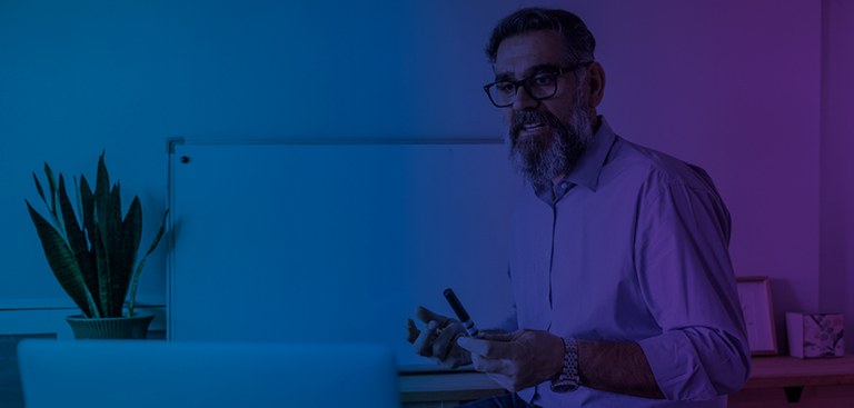 Fotografia de um professor dando aulas e interagindo com alunos por meio de um computador Fotografia de um professor dando aulas e interagindo com alunos por meio de um computador