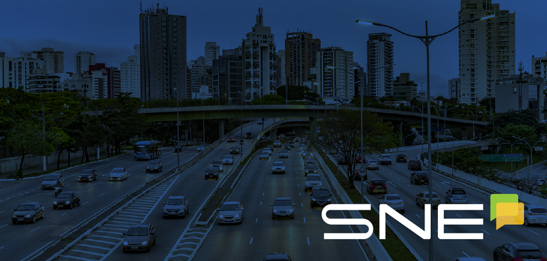 Imagem da cidade de São Paulo sob filtro na cor azul. No canto à direita, a marca do SNE Imagem da cidade de São Paulo sob filtro na cor azul. No canto à direita, a marca do SNE