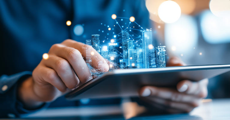 Imagem de uma pessoa operando um tablet do qual se vê projetado o holograma de uma cidade