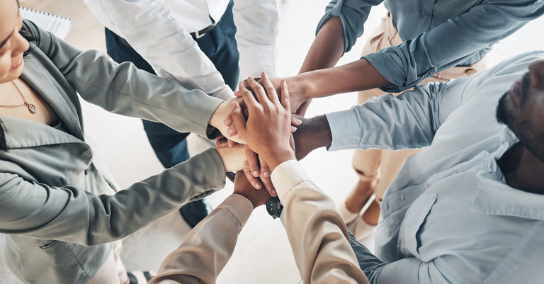 Fotografia de pessoas dando-se as mãos para representar trabalho de equipe, motivação e sucesso nos resultados