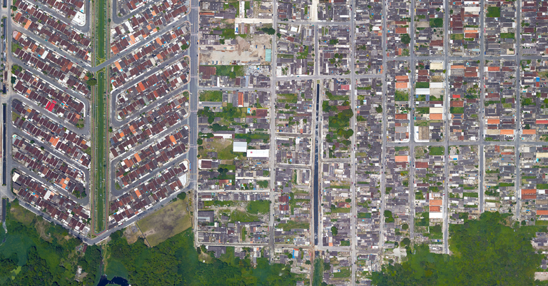Vista aérea de uma cidade mostrando um bairro que faz limite com uma floresta